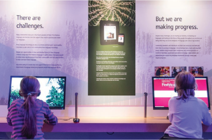 Two children sitting at interactive screens in the Our LIving Languages exhibit
