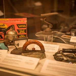 Display in the museum’s main room showcasing a variety of iron degns from the early 1900s to the 1940s