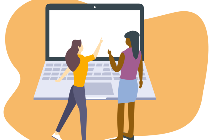 Two people looking and pointing at a large laptop